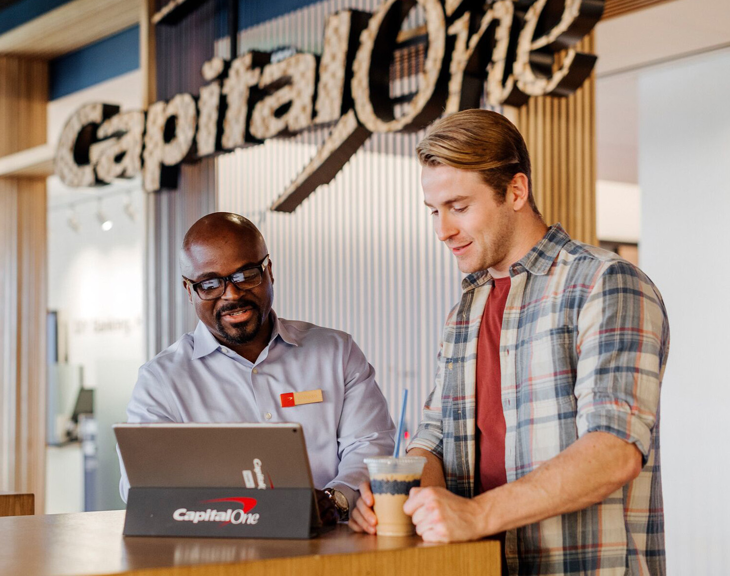 A Capital One Cafe Ambassador helps a customer